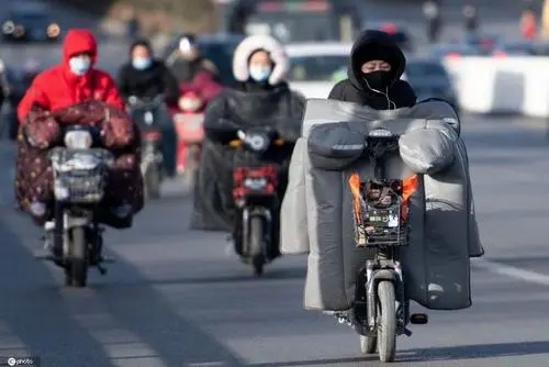 河南气温骤降俩小伙裹棉被骑车，此举存在哪些安全隐患？